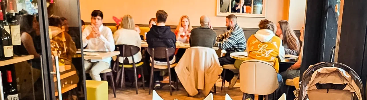 Sala de Masa Divina llena de gente cenando en mesas de grupo